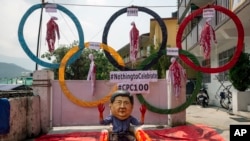 Un activist tibetan din Dharmsala, India, poartă o mască cu Președintele Chinei, Xi Jinping, într-o cadă plină de „sânge” în semn de protest față de comemorarea a 100 de ani de la fondarea Partidului Comunist Chinez. Fotografie realizată la data de 1 iulie 2021.