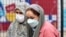 Women wearing face masks to protect themselves from air pollution walk on a street in Tehran on November 29.