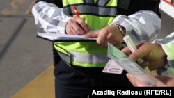 Arxiv fotosu - Yol polisi sürücünü cərimələyir