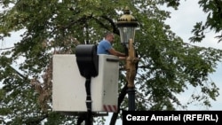 Un angajat al companiei Electrica demontează corpurile de iluminat de pe stâlpii din Piața Unirii 11 iunie 2025.