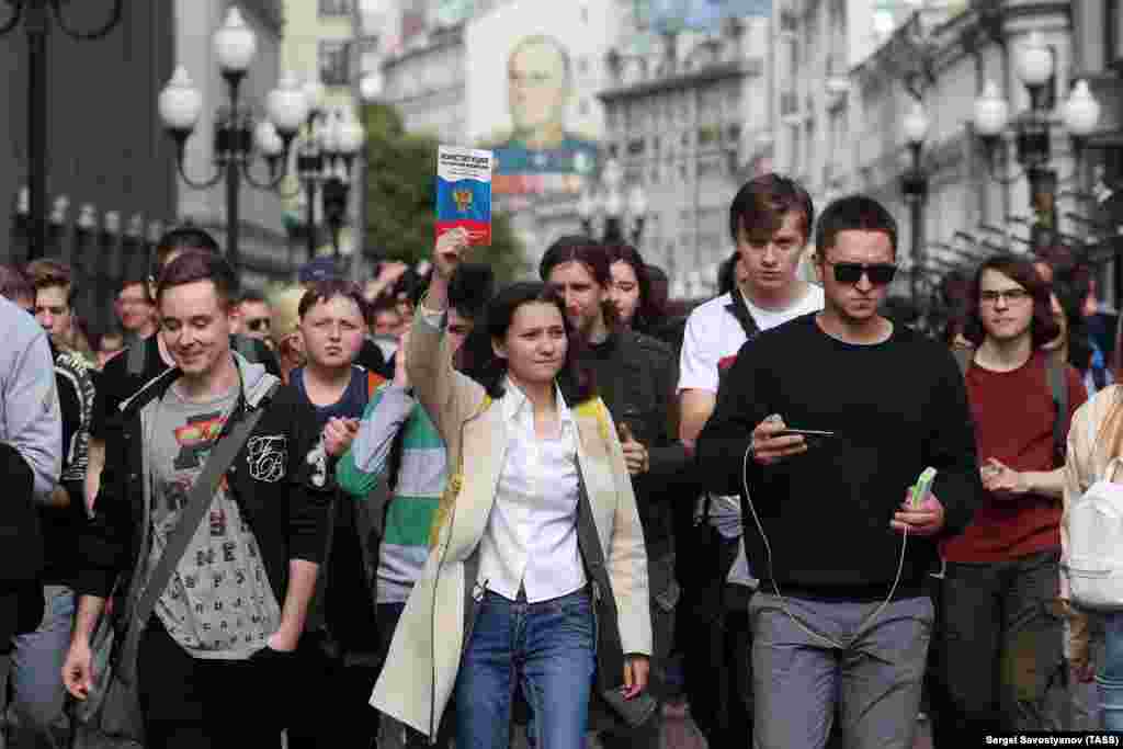 A protester holds aloft a copy of Russia's constitution, which guarantees freedom of assembly and free speech.&nbsp;