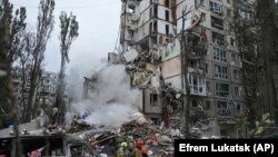 Рятувальники у Святошинському районі, де російська ракета повністю знищила підʼїзд дев’ятиповерхового житлового будинку, 31 липня 2025 року