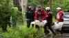 Emergency workers carry the body of a resident who died when a Russian drone hit an apartment building in Kyiv on May 7.