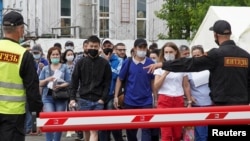   Охранники указывают путь трудовым мигрантам, которые приедут за разовой вакциной Sputnik Light против COVID-19.