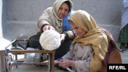 آرشیف - یک خانم افغان در حال تهیه تار برای قالین بافی از پشم گوسفند - عکس جنبه تزیینی دارد
