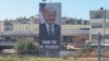 Motorists drive past a billboard depicting US President Donald Trump in Tel Aviv on October 10, 2025.