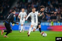 Mesfushori i Sllovenisë, Tomi Horvat, dhe mesfushori i Kosovës, Leon Avdullahu (djathtas) luftojnë për topin gjatë ndeshjes kualifikuese të Grupit B të Kampionatit Evropian FIFA 2026 midis Sllovenisë dhe Kosovës në Lubjanë.