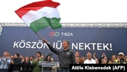 Lider partije Tisza, Peter Mađar, mađe mađarskom zastavom za govornicom, Budimpešta, 13. april 2025.