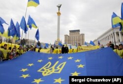Молодь тримає прапор Євросоюзу з гербом України на майдані Незалежності в Києві, 30 жовтня 2013 року
