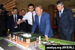Президент Казахстана Нурсултан Назарбаев (в центре) рассматривает макет ресторана McDonalds. Слева от него стоит Кайрат Боранбаев. Астана, 5 марта 2016 года.