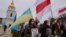 Люди вшановували пам'ять загиблих за Україну білорусів, тримаючи в руках їхні портрети, прапори України та біло-червоно-білі стяги (історичний прапор Білорусі)
