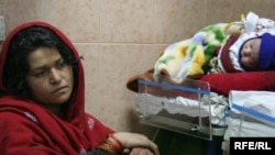 یوه افغان ښځه د خپل ناروغ ماشوم له بستر سره 