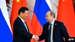 Russian President Vladimir Putin (right) shakes hands with his Chinese counterpart Xi Jinping during a ceremony to mark the signing of a number of bilateral traded deals in Moscow on May 8. 