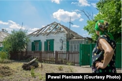 Іловайськ, жінка біля свого зруйнованого будинку. Фото: Павел Пеньонжек