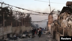 A migrant walks among destroyed shelters following a fire at the Moria migrant camp on the island of Lesbos on September 9. 
