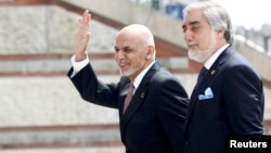 Afghan President Ashraf Ghani (right) with the country's Chief Executive Officer Abdullah Abdullah as they arrive for the NATO summit in Warsaw in July 2016.