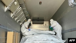 Представители Международного комитета Красного Креста проверяют мешки с останками военнослужащих во время обмена телами, август 2024 года