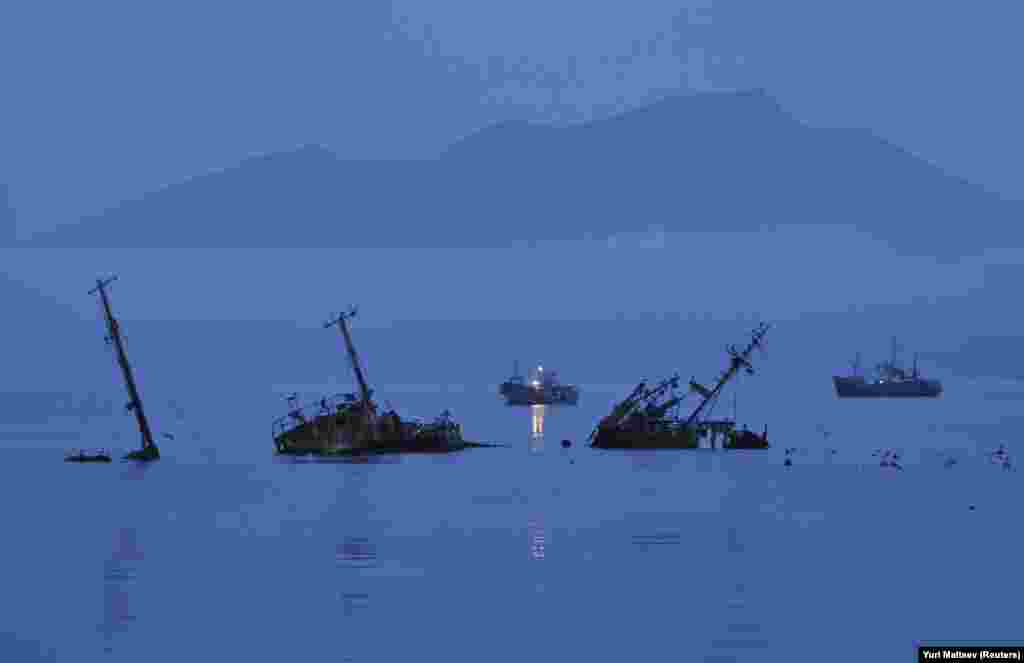 Сумерки в порту Кунашира. Рыболовство &ndash; основной источник дохода местного населения, но инфраструктура разрушена и перспективы экономического развития выглядят очень печально. В 2005 году один из изгнанных с острова японцев побывал на острове и заметил, что его бывшая родина теперь &ndash; "потерянная земля".