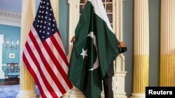 د امریکا د بهرنیو چارو وزارت یو کارکوونکی د پاکستانیو او امریکايي چارواکو تر لیدو مخکې د پاکستان بیرغ سموي - انځور له ارشیفه