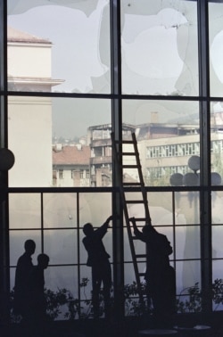 Workers place plastic sheets over the shattered lobby windows of the Holiday Inn in September 1992.