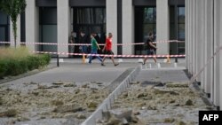 People walk past a high-rise residential building damaged by the remains of a downed Russian drone in Kyiv on July 13. 