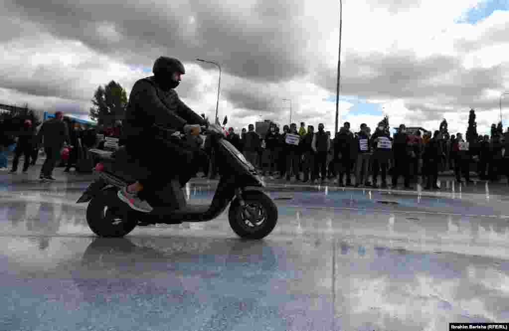 Një motoçiklist kalon pranë protestës së qumështarëve.