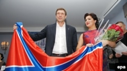 Soprana Anna Netrebko și președintele „Parlamentului” așa-numitei Noua Rusie, Oleg Tzarev fotografiați cu steagul noii republici separatiste la St. Petersburg, 8 decembrie 2014