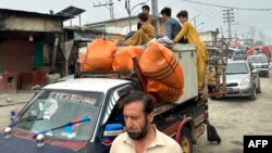 یوه کډواله کورنۍ د باجوړ په مرکز خار کې د کیمپ پر لوري روانه ده - د اګست ۱۳مې انځور. 