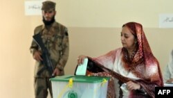 یو پوځي سرتېری د ۲۰۱۳ز کال د انتخاباتو پر مهال د ووټ اچونې په مرکز کې پهره ورکوي ـ انځور له ارشیفه.