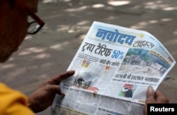 Muškarac čita novine s izvještajima o tarifama nakon što je američki predsjednik Donald Trump najavio dodatnih 25 posto tarife na indijsku robu, pored pijace u New Delhiju, Indija, 7. avgusta 2025.