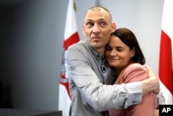 Сергій Тихановський (ліворуч), білоруський опозиційний активіст, звільнений з білоруської в'язниці, обіймає свою дружину, білоруську опозиційну лідерку Світлану Тихановську після пресконференції у Вільнюсі, Литва, 22 червня 2025 року