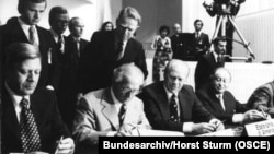 هلموت اشمیت، صدراعظم آلمان غربی (چپ)، اریش هونکر، رهبر آلمان شرقی (دومین نفر از چپ) و جرالد فورد، رئیس جمهور آمریکا، هنگام امضای سند نهایی هلسینکی، یکم اوت ۱۹۷۵
