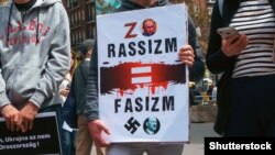 Плакат із зображенням російського президента Володимира Путіна і Гітлера під час акції з вимогою зупинити збройну агресію Росії проти України. Будапешт, Угорщина, 8 березня 2022 року 