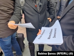 Protestatarii împart foi cu mesaje prin care cer democrație în diferite țări europene, plus SUA.