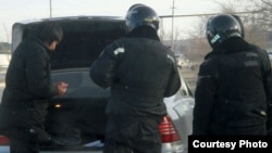 Полицейские проводят досмотр машины. Жанаозен, 19 декабря 2011 года. Фото Елены Костюченко, "Новая газета".