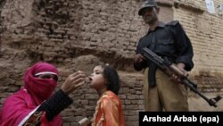 په پېښور کې یو پولیس سرتېری د پولیو واکسیني ډلې د امنیت لپاره ولاړ دی - پخوانی انځور.