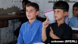 Afghan refugee children attend lessons at the refugee camp where they live near Peshawar, Pakistan.