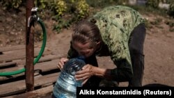 Една жена пие чиста вода во источниот град Славјанск