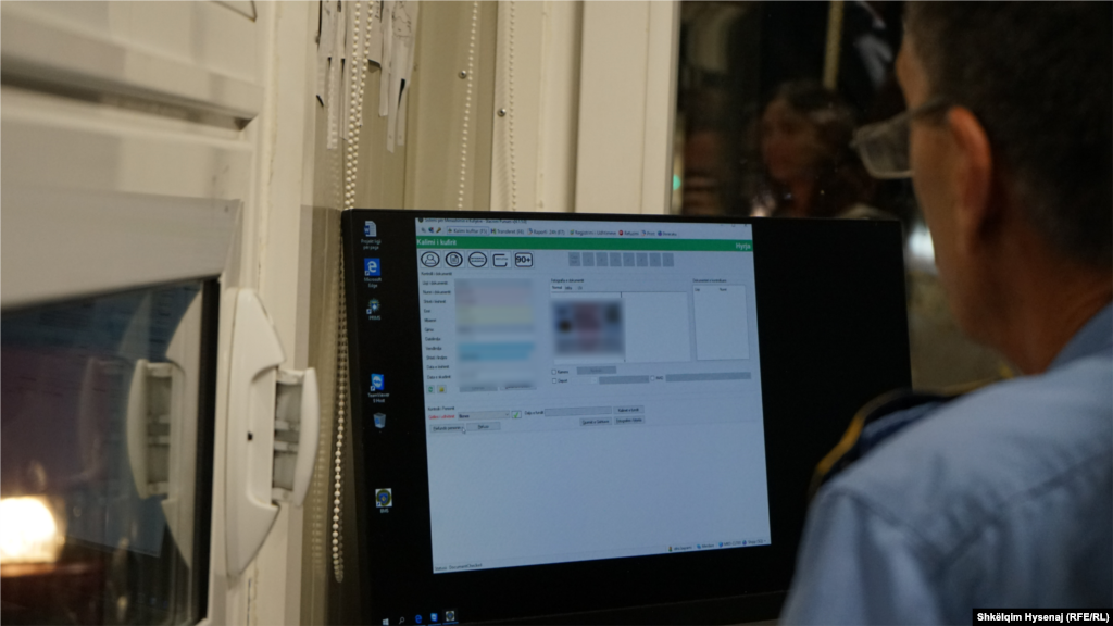 Nje zyrtar i Policisë së Kosovës duke bërë gati dokumentin për hyrje/dalje për një qytetar të Serbisë, gjatë orës së parë të 1 gushtit 2022.