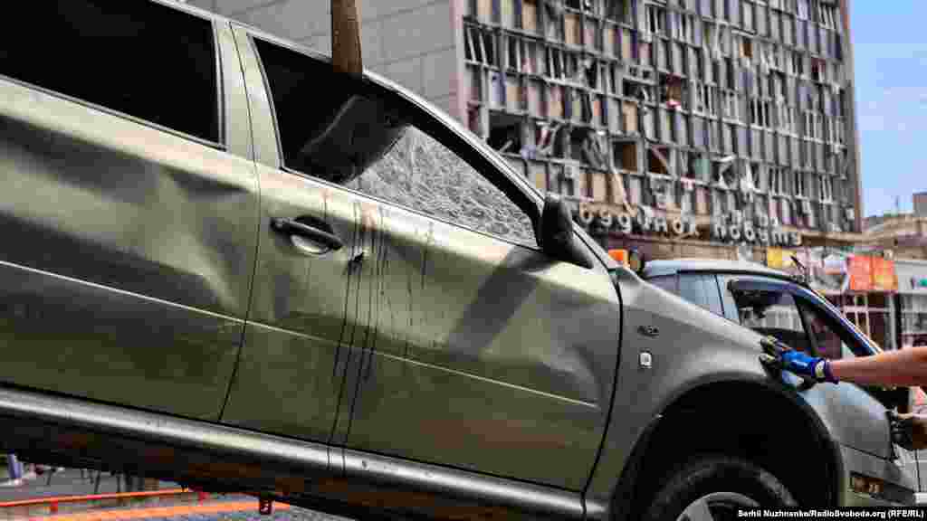 Евакуація пошкодженого автомобіля з місця обстрілу. На машині залишилися сліди крові і вм'ятини від уламків ракети