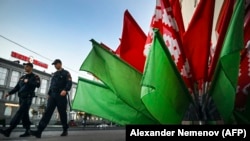 Нарад міліцыі праходзіць каля інсталяцыі ў колерах дзяржаўнага сьцяга. Менск, 21 ліпеня 2022 году