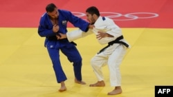 Таджикский дзюдоист Эмомали Нурали (справа) со своим соперником Барухом Шмаиловым из Израиля. Париж, 28 июля 2024 г.