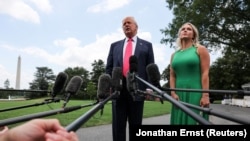 Președintele SUA, Donald Trump, discută cu reporterii, alături de secretara de presă a Casei Albe, Karoline Leavitt, 15 iulie 2025.