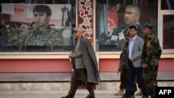 FILE: Afghan Vice President Abdul Rashid Dostum (L) walks at his headquarters in Sheberghan, capital of northern Jowzjan province on July 28.