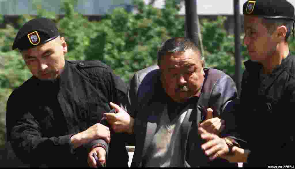 Попытки провести протесты "по земельному вопросу" предпринимались в Алматы и до 21 мая 2016 года, за несколько недель до этой даты. Однако немногочисленных активистов, приходивших на центральную площадь, тотчас же задерживали. На фото: полиция задерживает мужчину рядом с монументом Независимости 7 мая 2016 года.