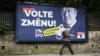 ფეხით მოსიარულე ულტრამემარჯვენე პარტიის საარჩევნო ბილბორდთან, რომელიც ჩეხებს „ცვლილებებისთვის ხმის მიცემისკენ“ მოუწოდებს.