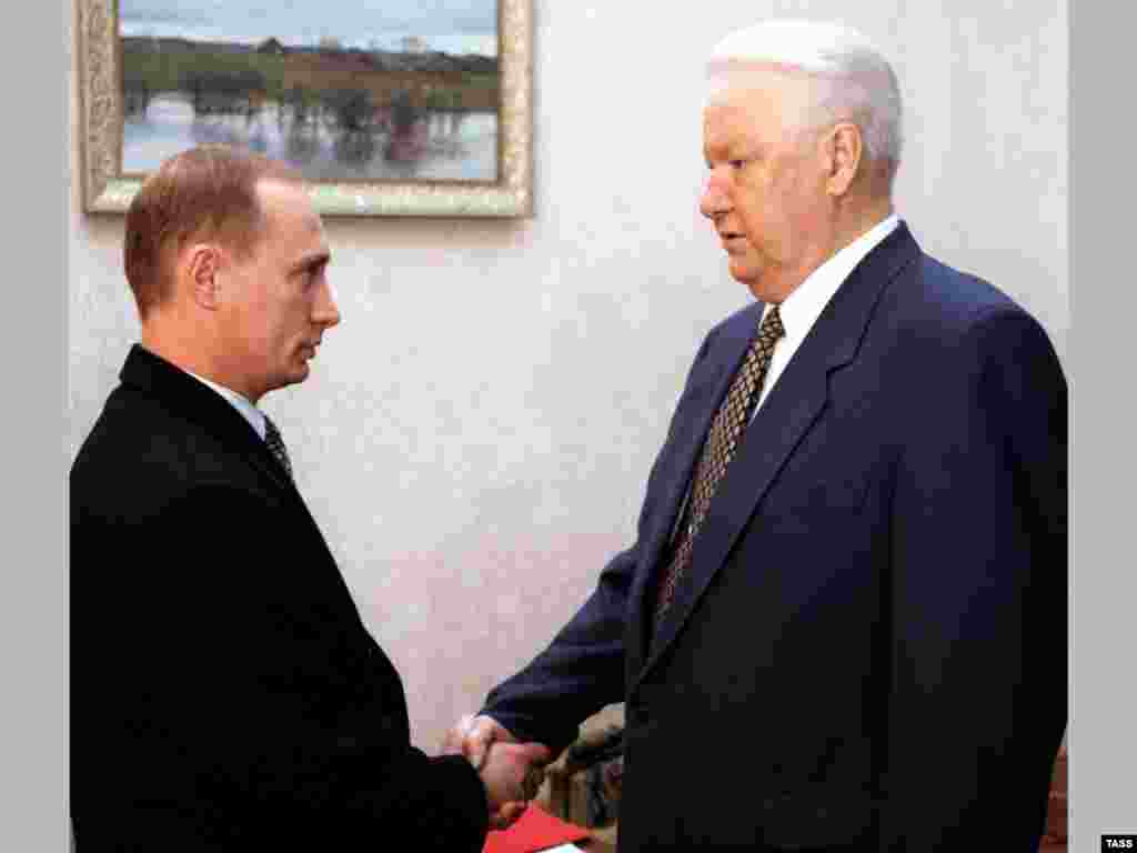 10 noiembrie 1998. Președintele rus Boris Elțîn (dreapta) dă mâna cu Putin la reședința sa Gorki din Moscova. În luna iulie a acelui an, Elțîn l-a numit pe Putin&nbsp;la conducerea Serviciului Federal de Securitate (FSB).
