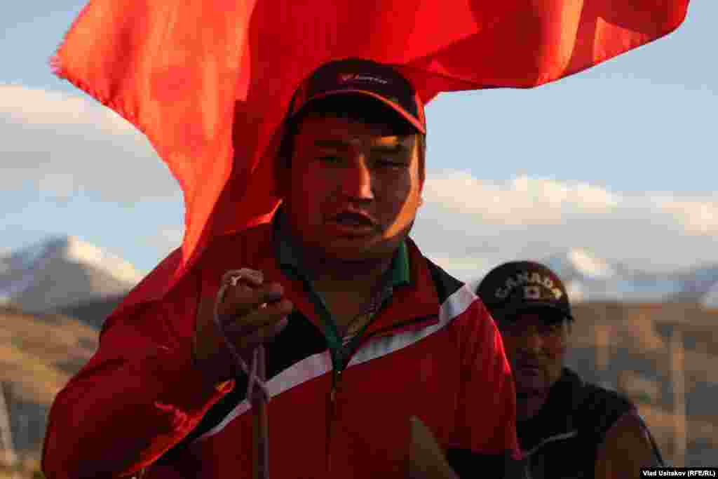 A protester carries a Kyrgyz flag.
