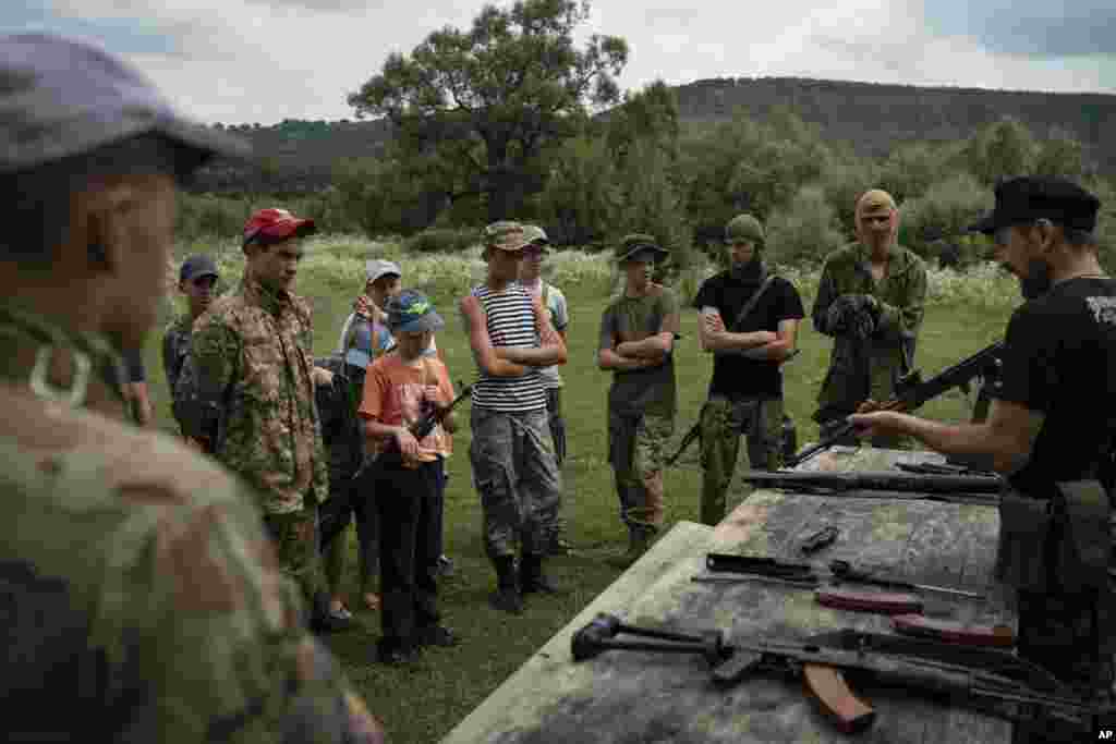 Бас инструктор Юрий "Чернота" Черкашин (оң жақта) балаларға "Калашников" автоматын жинауды үйретіп жатыр. Лагерьдегі балалар "елін ресейліктерден қорғауды үйреніп, ұлттық идеологияны сіңіреді". Бұл орталықты Украинадағы "Свобода" социал-ұлттық партиясының жастар қанаты құрған.&nbsp; &nbsp;