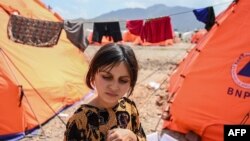 په ننګرهار کې یوه نجلۍ له پاکستانه تر ستنېدو وروسته په لنډمهالي کیمپ کې له خپلې خیمې سره ولاړه ده - د اپرېل ۲۰مې انځور.